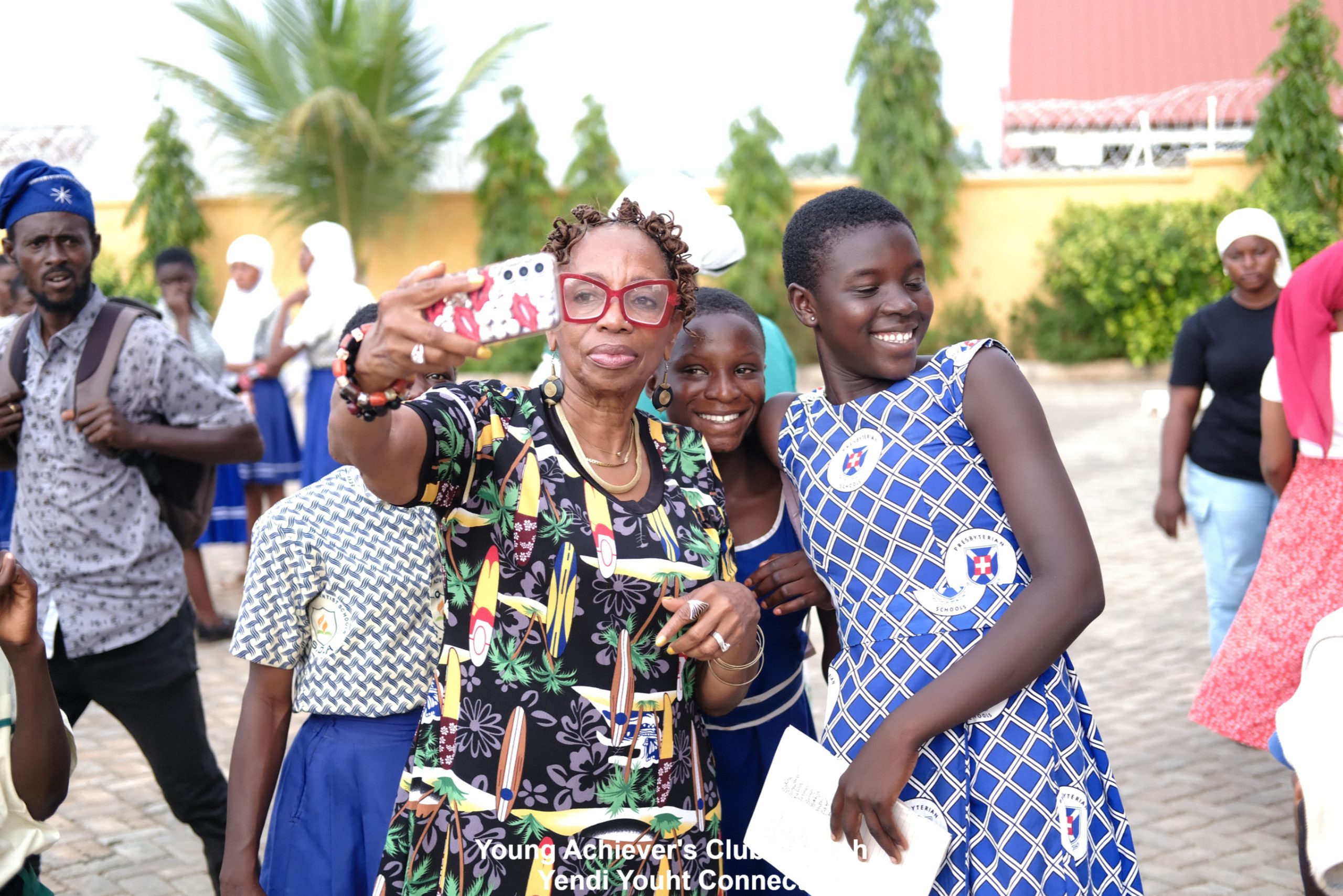 Miss Melannie Denise Cunningham taking a picture with some of the Yendi Youth Connect Young Achievers Club members
